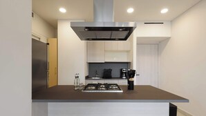 A modern kitchen with a central island, stainless steel appliances, and a built-in range hood. - Magnifico Nuevo Departamento a Pasos de Polanco (Ciudad de México)