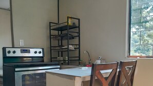 A kitchen with a stove, sink, and a shelf with dishes. - Beach apartment kilometer 59 (Rural area-Surf city). (La Libertad Department)