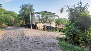 A cobblestone path leading to a building with a metal roof and a concrete pillar. - Beach apartment kilometer 59 (Rural area-Surf city). (La Libertad Department)