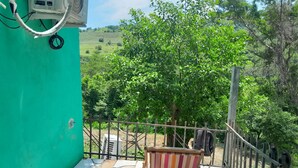A balcony with a green wall, a tiled floor, and a wooden chair. - Beach apartment kilometer 59 (Rural area-Surf city). (La Libertad Department)