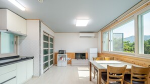 A modern kitchen with a dining area, large windows, and a view of greenery. - Goseong Sand & Sea Glamping & Pension (Goseong)
