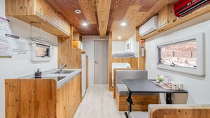 Una cuina compacta amb armaris de fusta, un rentaplat i una finestra amb vista a l'exterior.