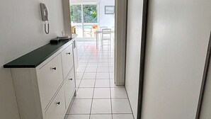 Moderni keittiö, jossa on valkoiset kaapit, musta työtaso ja seinälle asennettu puhelin.