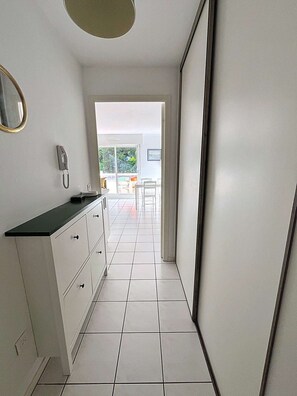 A modern kitchen with white cabinets, a black countertop, and a phone on the wall. - PORNICHET PLACE DU MARCHE (PORNICHET)