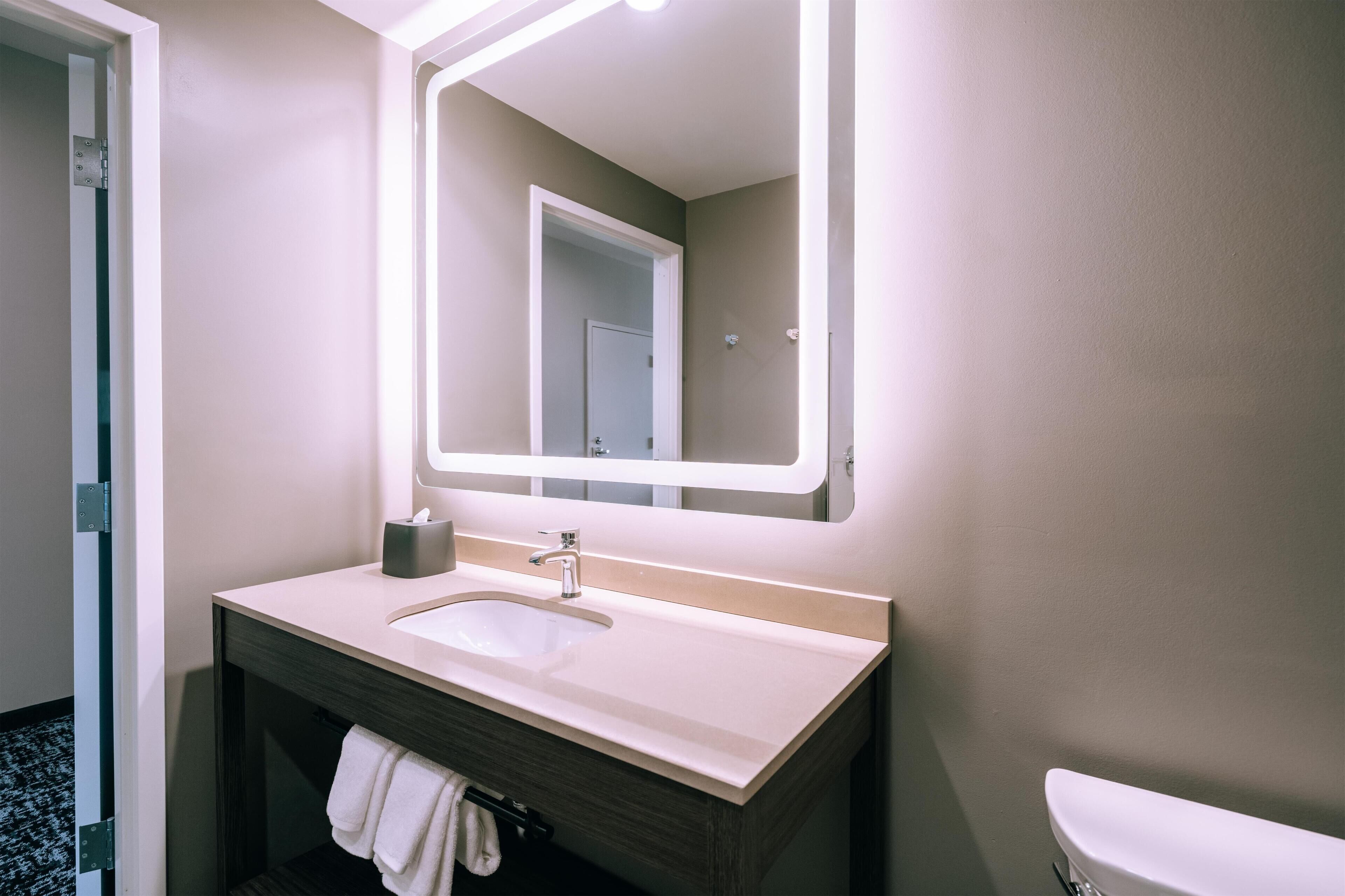 A bathroom with a sink, mirror, and toilet.