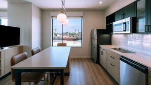 A modern kitchen with a dining area, a large window with a view, and built-in appliances. - Hyatt House Ontario Airport (Ontario)