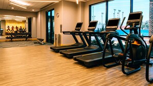 A gym with treadmills, exercise bikes, and weights.