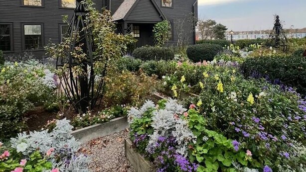 A dark-colored house with a garden in front.