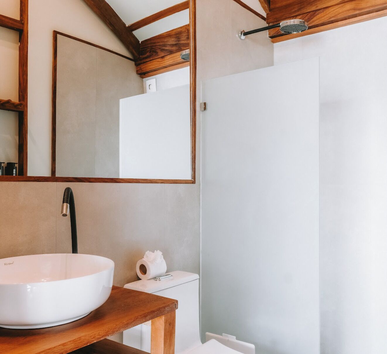Un baño con un lavabo grande blanco, un espejo y una ducha.