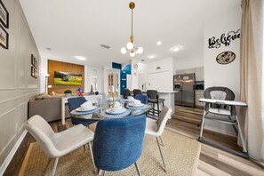 A modern dining area with a round table, chairs, and a high ceiling with recessed lighting. - 4720 HH - Fiesta Key Grandeur (Kissimmee)