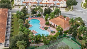 A residential area with a swimming pool, tennis court, and a row of houses. - 4720 HH - Fiesta Key Grandeur (Kissimmee)