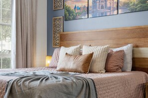 A bed with a wooden headboard, multiple pillows, and a textured blanket. - 4720 HH - Fiesta Key Grandeur (Kissimmee)
