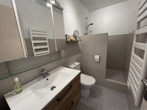A modern bathroom with a glass-fronted sink, a toilet, and a shower area. - SEAFRONT APARTMENT FOR 4 PEOPLE – TOWN CENTER (STE MAXIME)