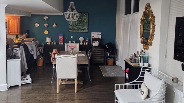 Amplia sala de estar con techo alto, una mesa de comedor, un sofá blanco y una lámpara decorativa.