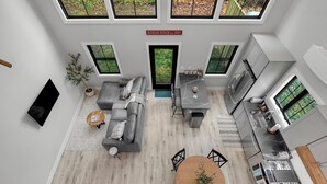 Un intérieur moderne comprenant un espace de vie, une cuisine et un coin repas, avec de grandes fenêtres offrant une vue sur l’extérieur.