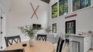 Une cuisine moderne avec un coin repas, de grandes fenêtres et une enseigne indiquant l’année de création de l’établissement.