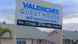 Schild für das Valencia's Guest House, das Apartments mit Selbstversorgung bewirbt.