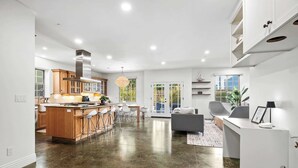 A spacious kitchen with a central island, wooden cabinets, and a large window. - Charming Coastal Getaway – 5 Min to Boardwalk! (Santa Cruz)