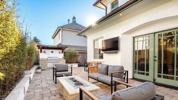 A patio with outdoor furniture, a barbecue area, and a television mounted on the wall. - Charming Coastal Getaway – 5 Min to Boardwalk! (Santa Cruz)