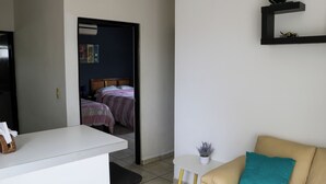 A room with a bed, a small table with a plant, a sofa, and a white desk. - Apartment No. 2, perfectly located with swimming pool (pets welcome) (Ciudad Madero)