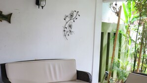 A room with a sofa, two chairs, a coffee table, a ceiling fan, a projector, and a decorative wall piece. - Apartment No. 2, perfectly located with swimming pool (pets welcome) (Ciudad Madero)
