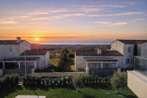 A residential area with stone buildings, a clear sky, and a sunset. - Design Villa  Emily White by Istrabook (Bale)