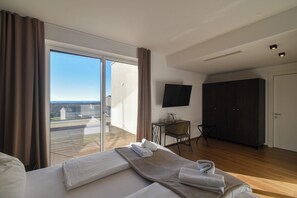 Ein Hotelzimmer mit Bett, Schreibtisch, Stuhl, Fernseher und Kleiderschrank.