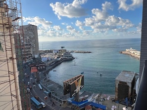 A coastal cityscape with a view of the sea, a pier, and a large billboard. - Charming 3-bedroom apartment with AC in Alexandria Governorate (Alexandria Governorate)