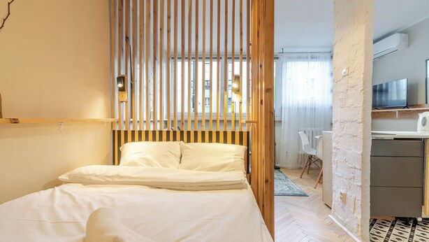 Ein modernes Hotelzimmer mit Bett, Schreibtisch und Fernseher.