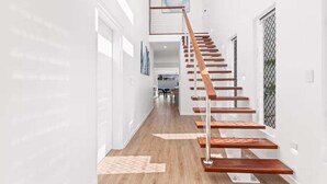 Eine moderne Treppe mit Holzstufen und Metallgeländern, die zu einer oberen Etage führt.