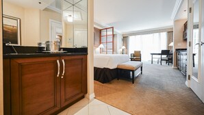 Een hotelkamer met een bed, een tafeltje, een stoel, een bureau en een kitchenette.