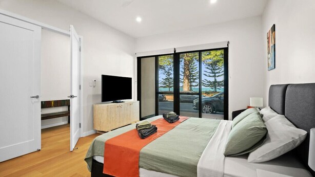 Une chambre moderne avec un lit, une télévision et une vue sur l’extérieur.