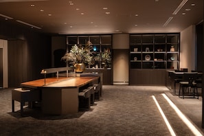Een modern interieur met een centrale eettafel, zitplaatsen en een decoratieve plantenpresentatie.