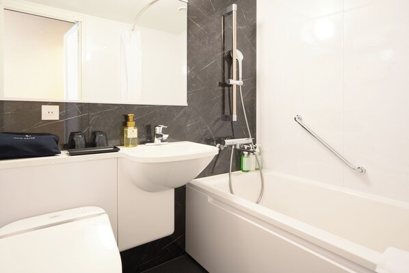 A modern bathroom with a white sink, a bathtub, and a hair dryer on the counter.