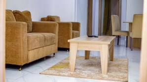 Un salon avec un canapé, une table basse et un fauteuil.