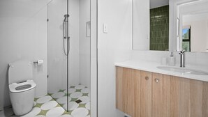 Un bagno moderno con toilette, doccia e lavandino.