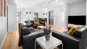 A modern living room with a sofa, coffee table, and a flat-screen TV.