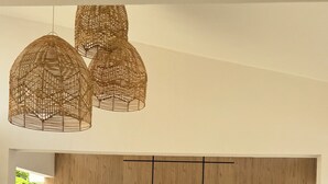 Un salon moderne avec un canapé d’angle, une table basse et deux plantes en pot.