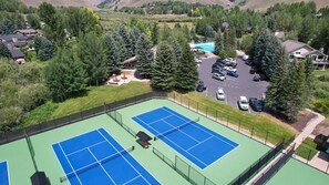 A tennis court with a pool and a parking area surrounded by trees. - Elkhorn Springs Retreat! With SVEA resort access! (Sun Valley)