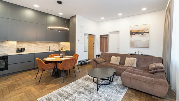 A modern living space with a kitchen, dining area, and seating area. - Vytauto 43 Residence – Lietūkis by Domvia (Kaunas)