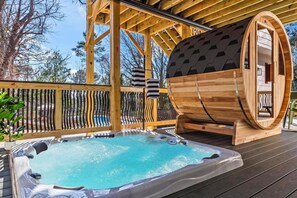 Eine Holzterrasse mit Whirlpool, Sauna und einem Holzbottich.