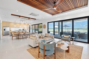 A modern living room with a sofa, armchairs, and a dining area. - Lakeside Villa with Private Pool & Hidden Beach (Providenciales)