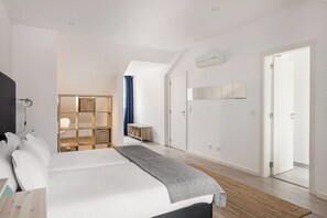 Ein modernes Schlafzimmer mit Bett, Nachttisch, Kleiderschrank, integriertem Bücherregal und einer Tür zu einem anderen Raum.