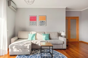 Ein Wohnzimmer mit einer Couch, einem Couchtisch und zwei Wandbildern.