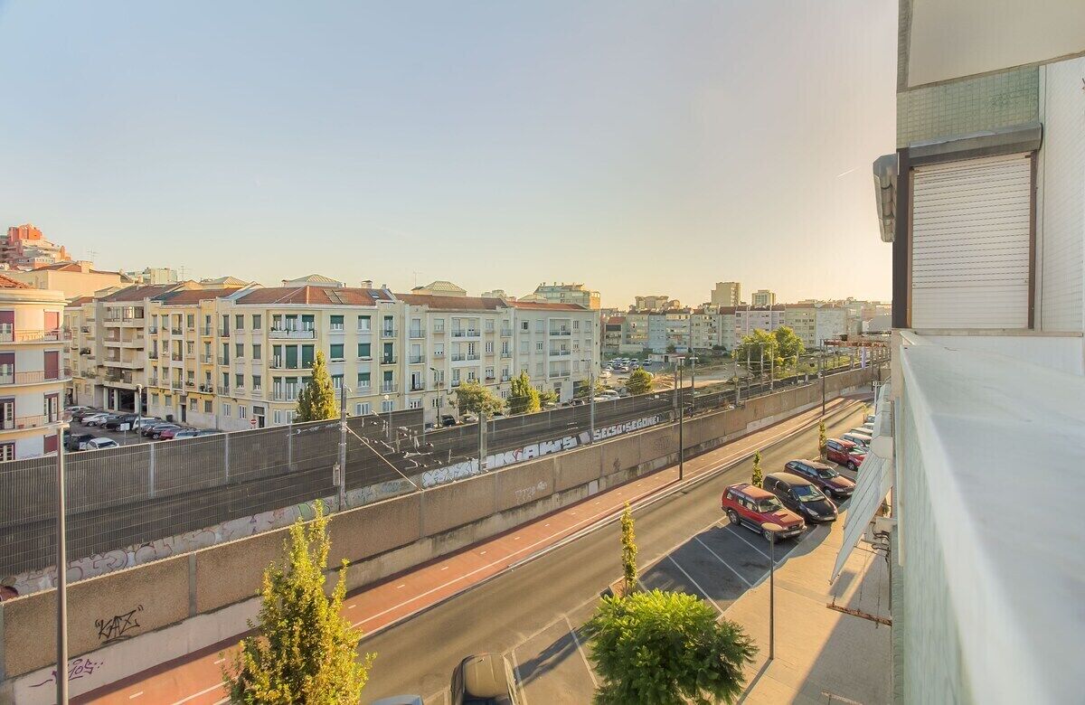 Un paisaje urbano con edificios de varios pisos, una calle con automóviles y una acera para peatones.