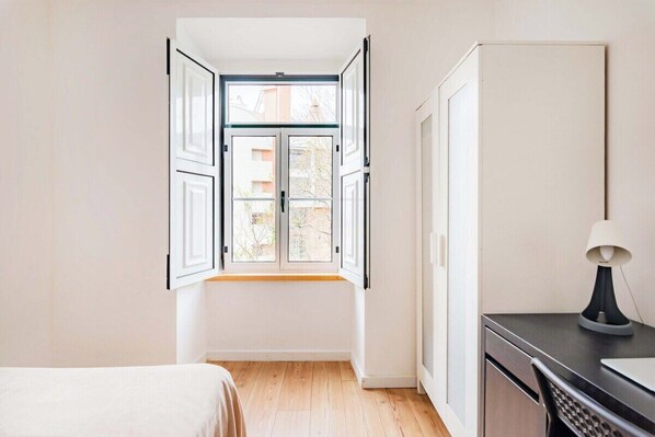 A room with a large window, a bed, a desk, and a cabinet. - Lisbon Viewpoint Retreat (Lisbon)