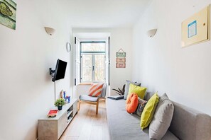 A modern living room with a sofa, a chair, a television, and a window. - Lisbon Viewpoint Retreat (Lisbon)