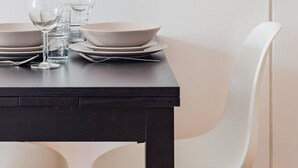 Una mesa de comedor con platos, vasos y una silla.