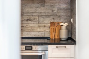Eine Küche mit Holzrückwand, einem Herd und einem weißen Schrank.