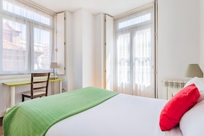 Ein Hotelzimmer mit Bett, Schreibtisch und Stuhl.